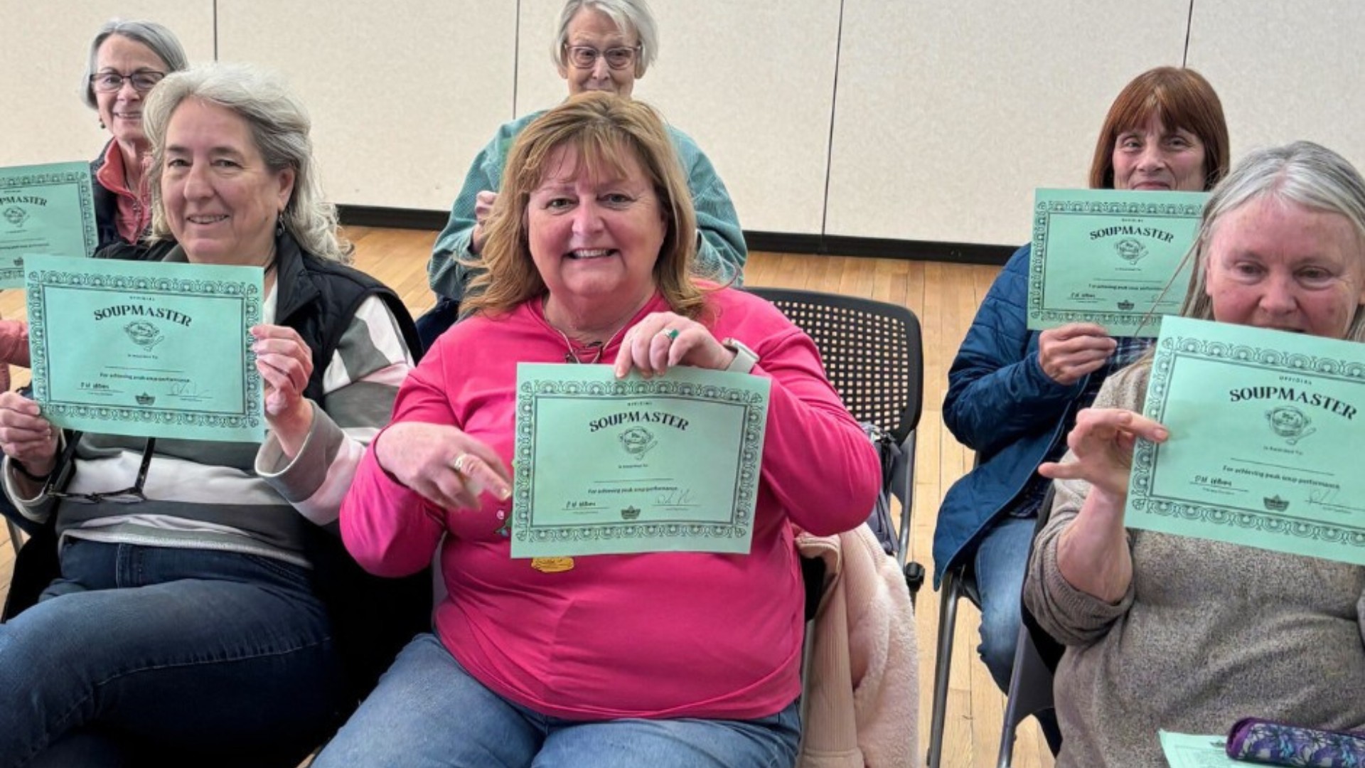 Participants holding SoupMaster certificates after a community program